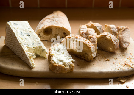 Le pain et le fromage sur une planche en bois en contre-jour. Banque D'Images