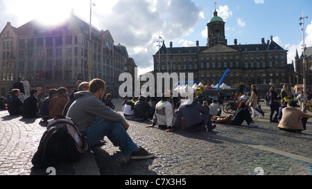 Les gens assis à proximité du Palais Royal (Koninklijk Paleis), Dam Square, Amsterdam, Pays-Bas. Banque D'Images