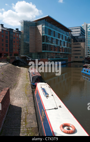 Au Piccadilly Narrowboats sur le bassin du canal de Rochdale, Manchester, Angleterre, Royaume-Uni. Building Design Partnership (PDE) Studio derrière. Banque D'Images