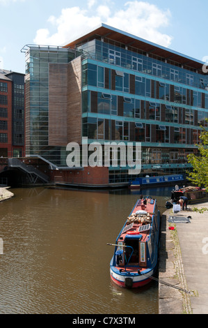 Au Piccadilly Narrowboats sur le bassin du canal de Rochdale, Manchester, Angleterre, Royaume-Uni. Building Design Partnership (PDE) Studio derrière. Banque D'Images