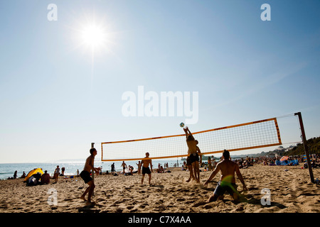 Un groupe jouer au volley-ball de plage dans la chaleur de l'après-midi sur la plage de Bournemouth. Banque D'Images