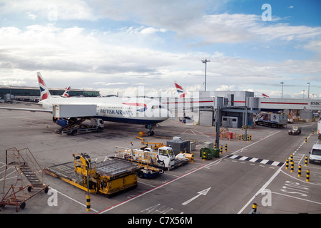 British Airways avion charger des bagages sur le tarmac, le Terminal 5 de l'aéroport Heathrow de Londres, UK Banque D'Images
