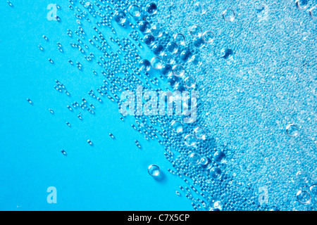 Perles de verre cristal de petites boules texture sur fond bleu Banque D'Images