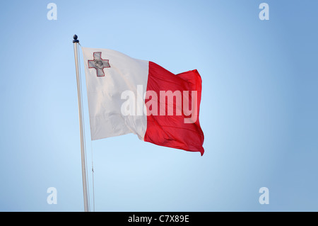 Brandir le drapeau maltais dans le vent. Banque D'Images