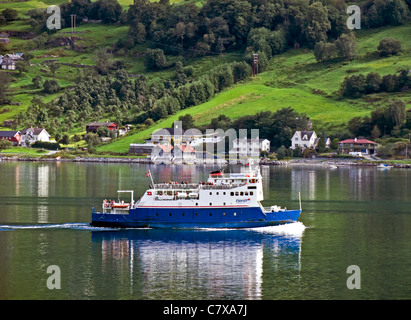 Fjord1 voiture et passagers M/S Skagastøl passant une petite colonie dans l'Naeroyfjorden dans l'ouest de la Norvège Banque D'Images