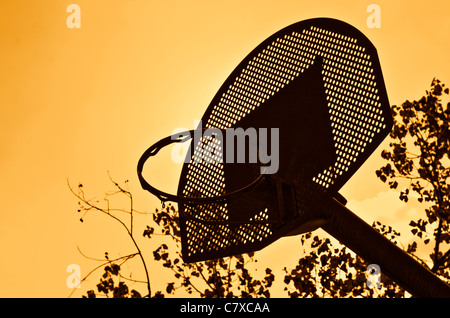 Panier de basket-ball d'ossature sur ciel coucher de soleil orange. Banque D'Images