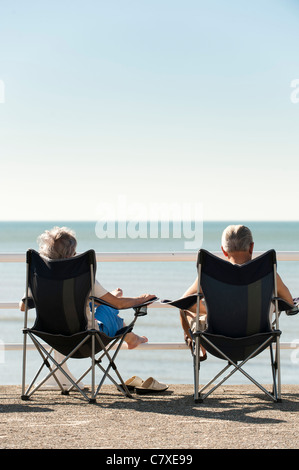 Un homme femme couple dans la toile des chaises pliantes profitant de la vague de la fin septembre 2011, Aberystwyth wales uk Banque D'Images