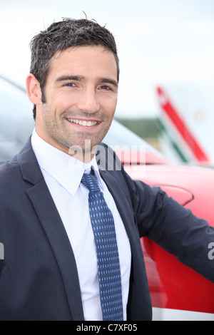 Smiling businessman debout à côté d'un avion léger Banque D'Images