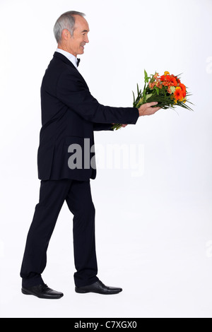 Homme habillé en tuxedo holding bunch of abaisse Banque D'Images