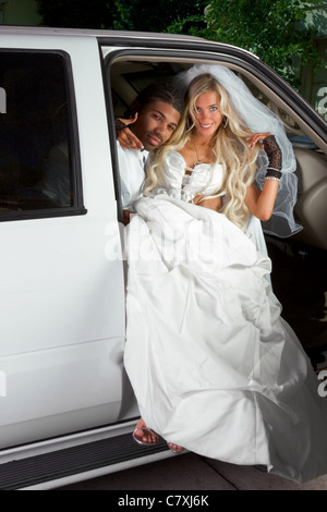 Young Caucasian woman in white robe de mariage magnifique sitting in car Banque D'Images