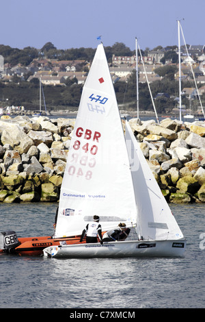 Les tuteurs de l'Académie de voile des Jeux olympiques de leurs étudiants de remorquage retour à la marina de Portland après une leçon Banque D'Images