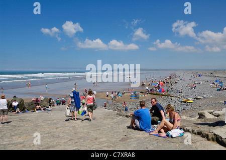 Les gens qui apprécient une journée d'été ensoleillée à Westward Ho! plage sur la côte nord du Devon, Angleterre. Banque D'Images