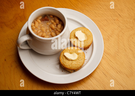 Style Cupcake cornbread beurré sur une plaque blanche avec bol de soupe de haricots Banque D'Images