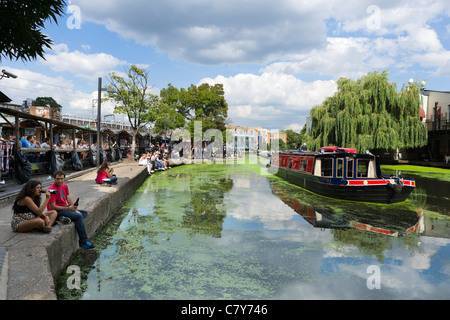 Les jeunes gens assis le long des rives de la Regent's Canal à Camden Lock, au nord de Londres, Angleterre, RU Banque D'Images