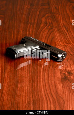 Neuf millimètres sur un poing reflective surface en bois Banque D'Images