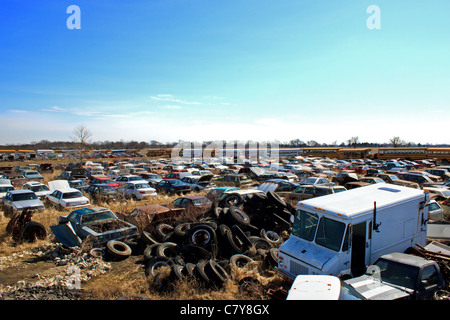 Automobile ancienne junkyard rempli de pneus, des camions, et des rangées d'autres véhicules Banque D'Images