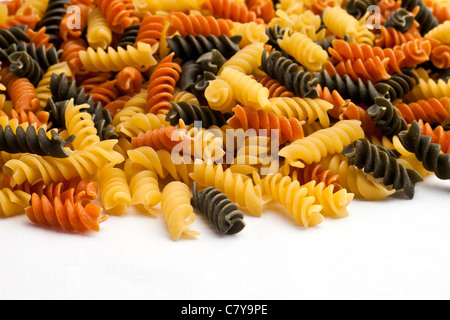 Nouilles pâtes tricolore répandus sur la surface blanche Banque D'Images