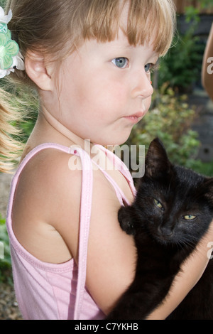 Petite fille embrasse par mains chaton Banque D'Images