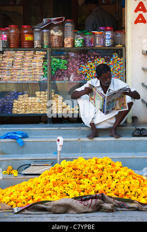 L'homme indien vente de fleurs de souci pour les offres de puja hindoue dans les rues de Puttaparthi, Andhra Pradesh, Inde Banque D'Images