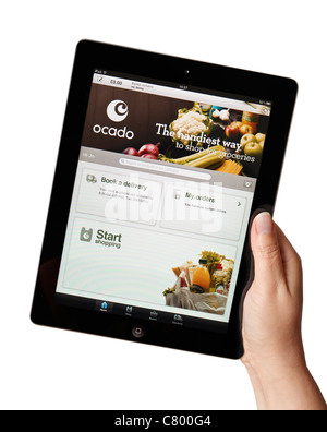 Main tenant un iPad montrant l'épicerie en ligne Ocado application Banque D'Images