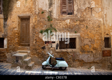 Vieux Vespa 50, garé dans la rue de Caltagirone (Sicile, Italie). Vintage Piaggio mobylette moto près de l'ancien bâtiment mur à Sicilia, Italie Banque D'Images