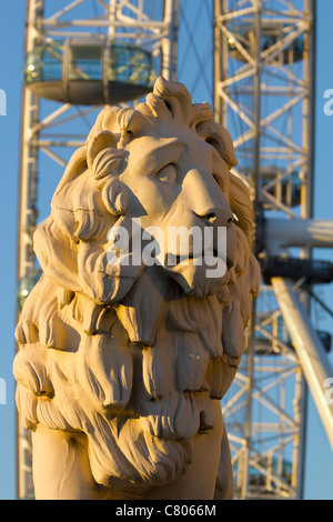 Coade stone lion à la fin de Westminster Bridge 2, London Eye en arrière-plan Banque D'Images