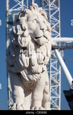 Coade stone lion à la fin de Westminster Bridge 3, London Eye en arrière-plan Banque D'Images