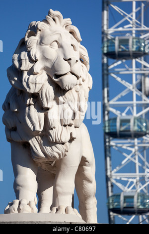 Coade stone lion à la fin de Westminster Bridge 4, London Eye en arrière-plan Banque D'Images