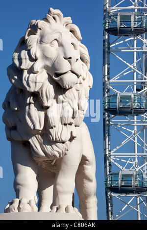 Coade stone lion à la fin de Westminster Bridge 5, London Eye en arrière-plan Banque D'Images