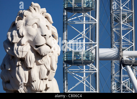 Coade stone lion à la fin de Westminster Bridge 6, London Eye en arrière-plan Banque D'Images