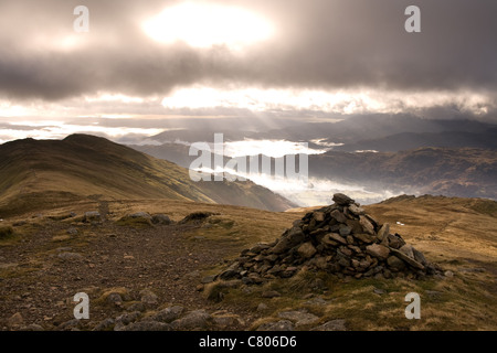 Un cairn sur le sommet de la Fairfield Horseshoe Ridge et la lumière du soleil à travers le brouillard d'eau couvertes valley Banque D'Images