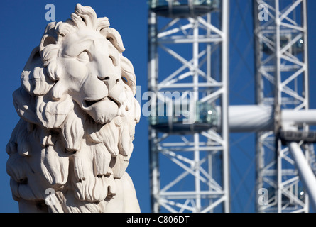 Coade stone lion à la fin de Westminster Bridge 7, London Eye en arrière-plan Banque D'Images