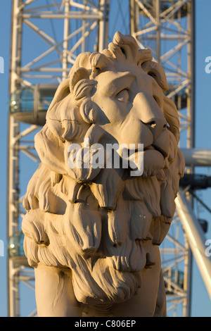 Coade stone lion à la fin de Westminster Bridge, London Eye en arrière-plan Banque D'Images