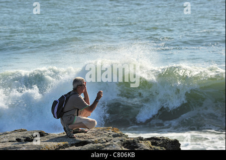 Prise de photos touristiques de vagues se brisant sur les rochers à la Pointe Saint-Gildas / Saint Gildas Point, Loire-Atlantique, France Banque D'Images