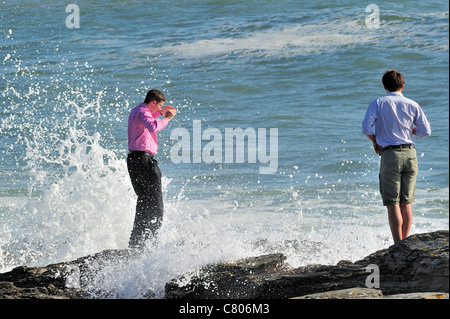 S touristiques trempé à partir de la vague se brisant sur les rochers, Pointe Saint-Gildas / Saint Gildas Point, Loire-Atlantique, France Banque D'Images