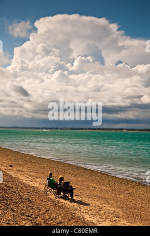 Deux personnes se détendre sur la plage de Cowes, île de Wight, Angleterre Banque D'Images