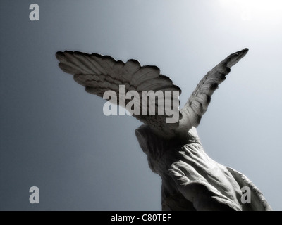 Statue en pierre de béton angel contre ciel bleu sun flare sculpture fly Banque D'Images