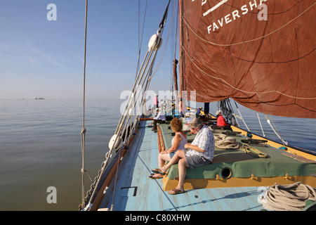 Une journée calme de la voile sur la barge, Greta de Whitstable, avec le sable rouge fort à l'horizon. Banque D'Images