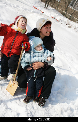 La mère et deux enfants à pied à l'hiver dans la cour Banque D'Images