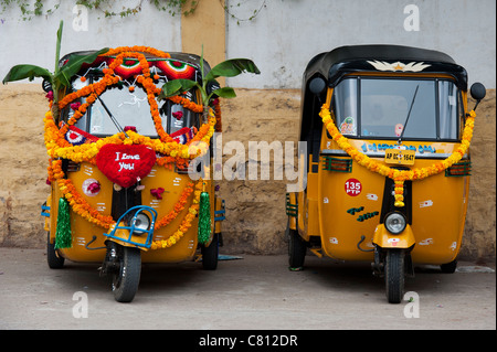 Rickshaw indien décorées de guirlandes de fleurs et de feuilles de bananier au cours de la fête hindoue du Dasara. L'Andhra Pradesh, Inde Banque D'Images