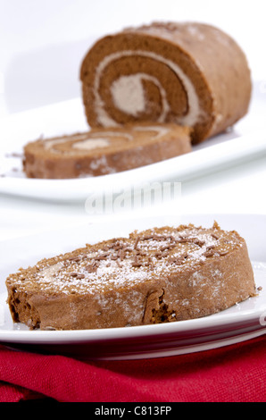 Swiss roll rempli de crème, quelques vermicelles de chocolat et sucre vanillé Banque D'Images