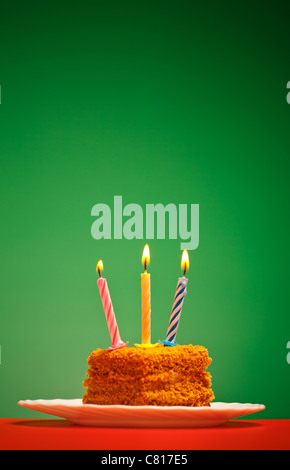 Gâteau d'anniversaire avec une bougie sur fond rose Banque D'Images