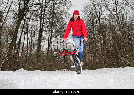 Flatland BMX rider Monika Hinz, école son vélo dans la neige, Bade-Wurtemberg, Allemagne Banque D'Images
