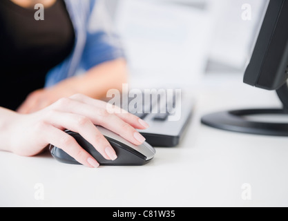 Close up of Korean woman using computer mouse Banque D'Images