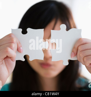 Femme coréenne tenant deux pièces du puzzle Banque D'Images