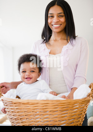 African American mother carrying baby boy in basket Banque D'Images