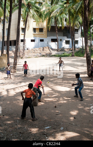 Les garçons à jouer au cricket indien sous les palmiers dans la ville de l'Inde rurale de Puttaparthi, Andhra Pradesh, Inde Banque D'Images