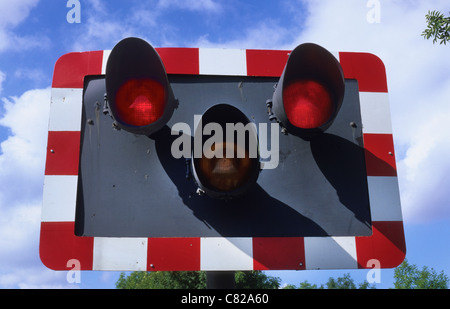 Feux clignotant en rouge au passage à niveau d'avertissement approche d'un train près de Leeds Yorkshire UK Banque D'Images