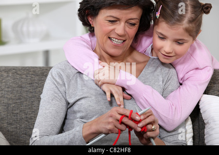 Une maman montrant comment tricoter pour sa fille. Banque D'Images