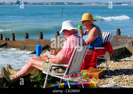Couple having picnic on West Wittering plage pavillon bleu de la plage sur une chaude journée d'automne. Près de Chichester, West Sussex, UK Banque D'Images